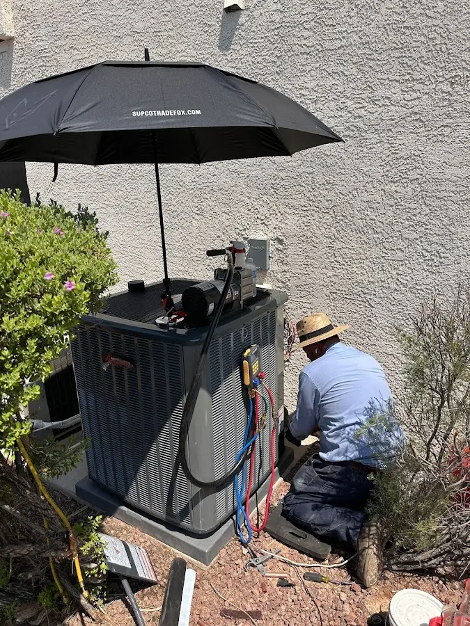 HVAC technician performing outdoor AC maintenance in Highland Park