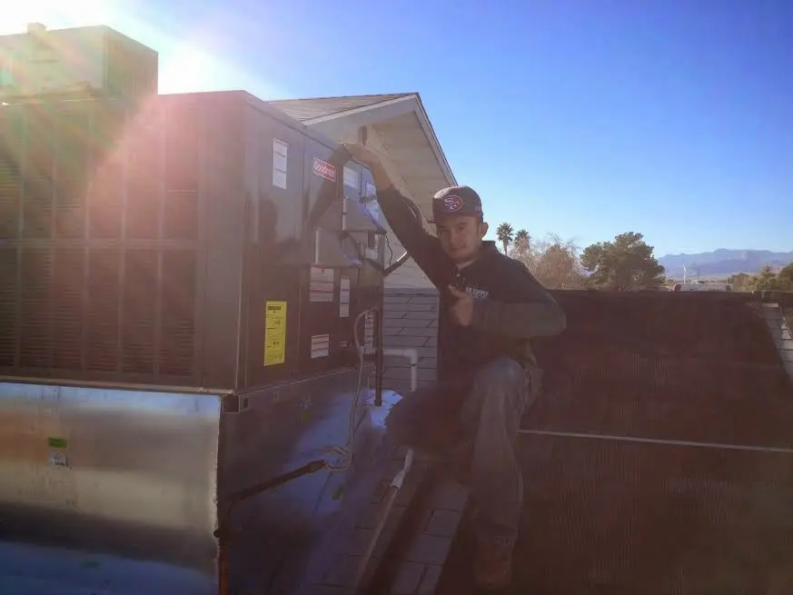 HVAC technician performing HVAC Inspection on a rooftop unit in Highland Park